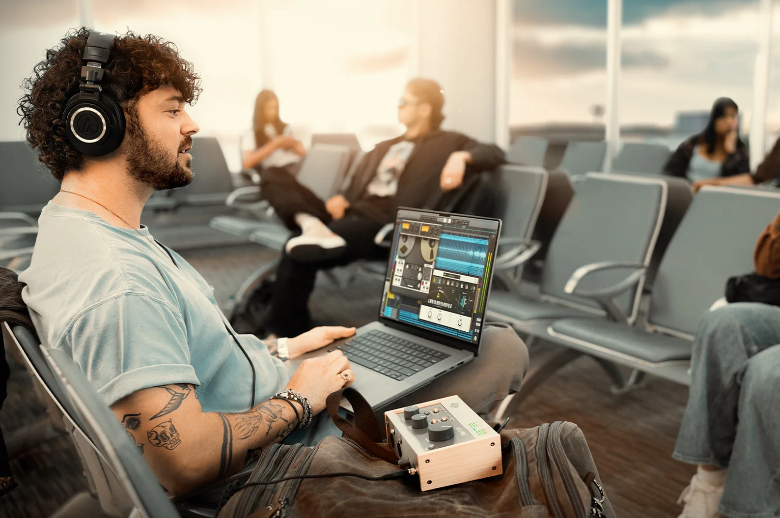 Produtor criando na LUNA pelo laptop numa sala de embarque